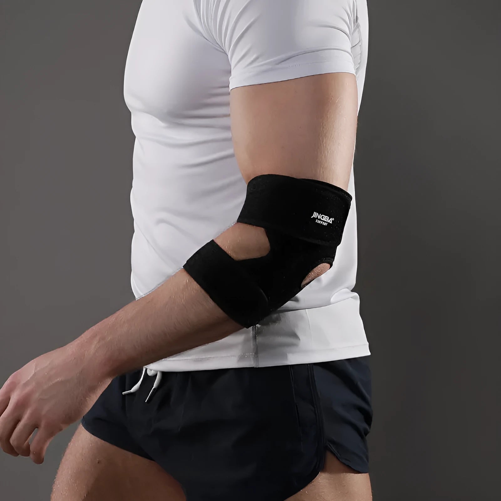Black adjustable sports elbow guard worn on arm for basketball and badminton support