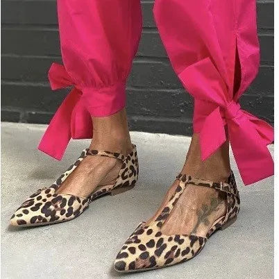 Leopard print women's pumps with pointed toe, cross strap, and a chunky low heel.