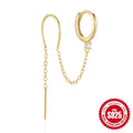 Close-up of a sterling silver stud earring with a geometric flower shape and dangling gold-tone tassel and chain details.