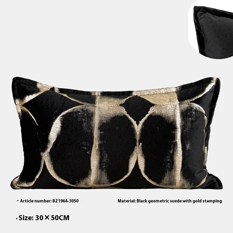 Black and gold abstract patterned square decorative pillow with a flannel cover on a grey sofa.