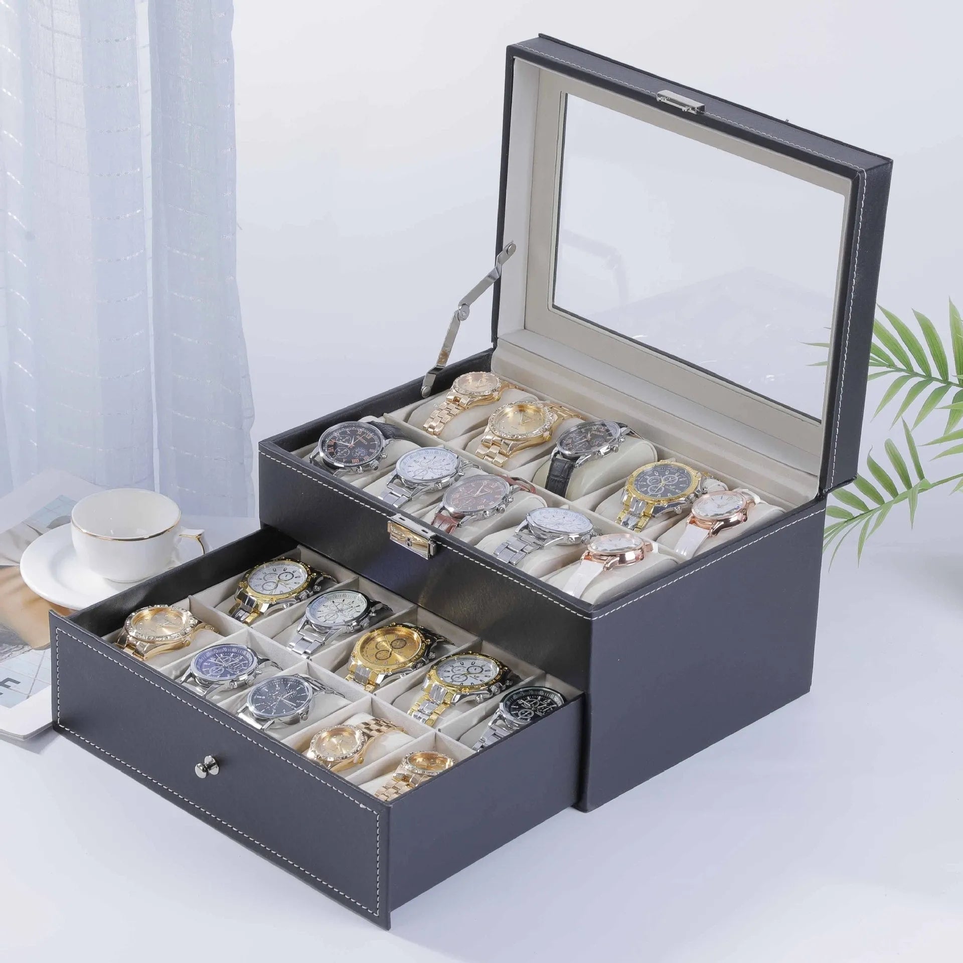 Grey leather watch storage box with transparent lid showing watch cushions inside.