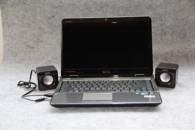 Small square black USB-powered 2.0 computer speaker on a desktop.