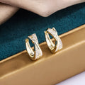 A pair of geometric drop earrings with zircon crystals in a 14K yellow finish.