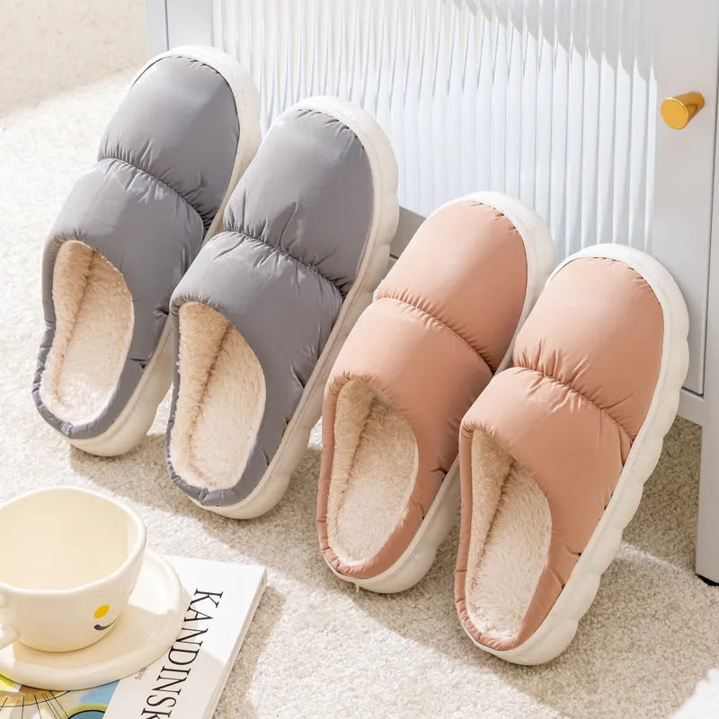 A pair of down cotton slippers with a thick rubber sole and artificial leather upper in a selected colour.