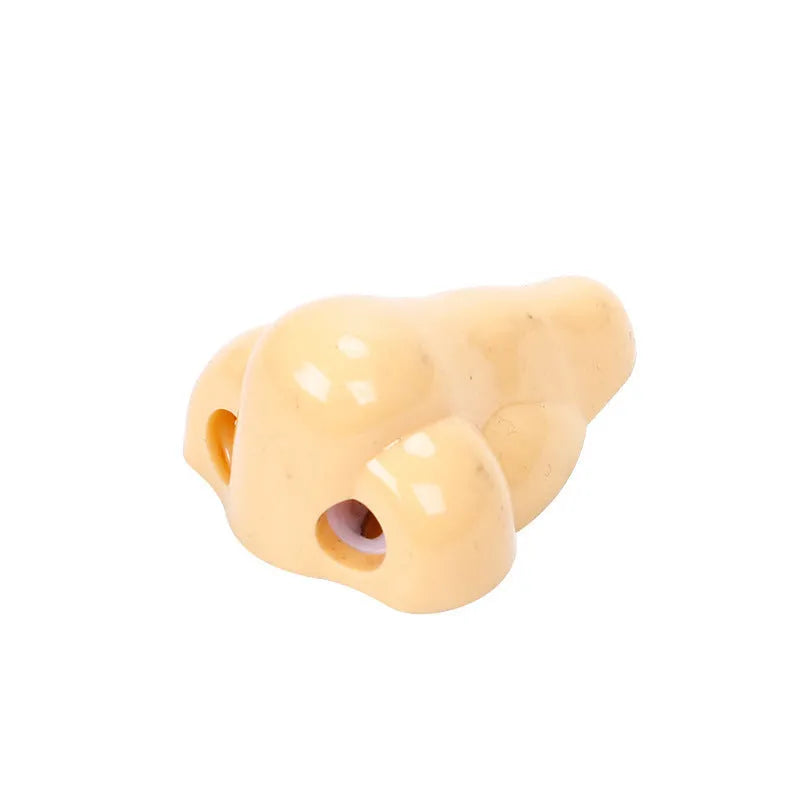 Flesh colour plastic geometry pencil sharpener with big nostril design on a white background.