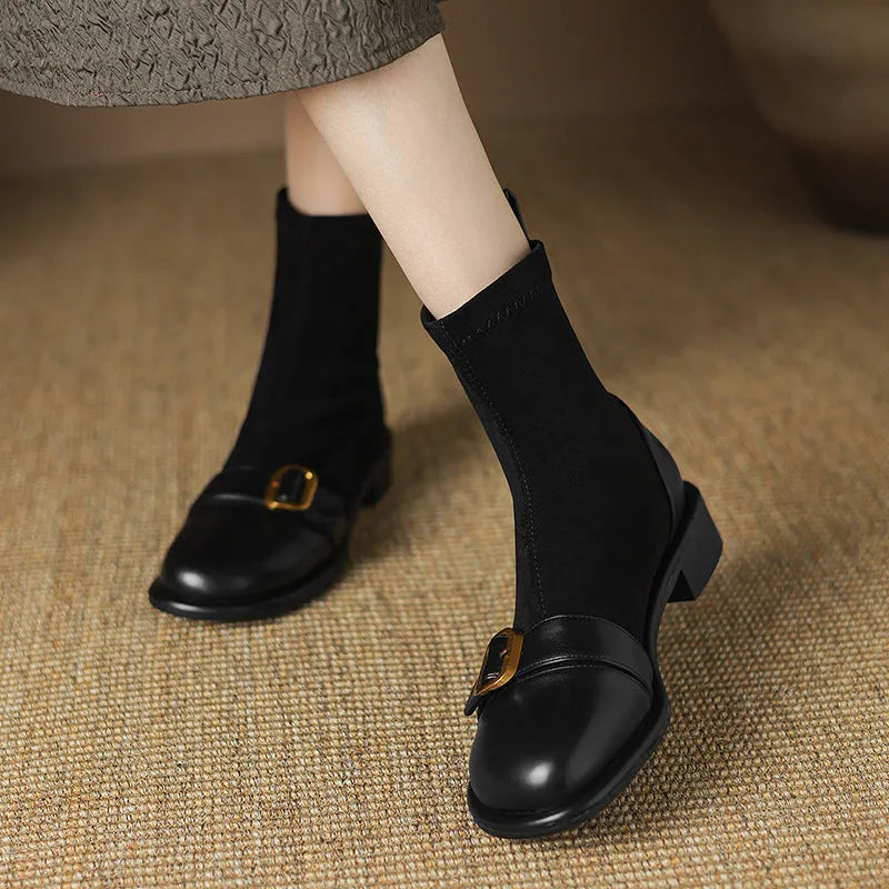 A pair of black women's lace-up Martin boots with a round toe and low rubber sole on a white background.