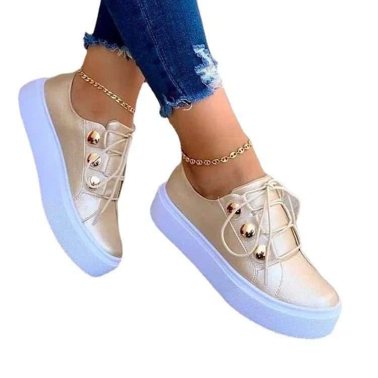 Women's white lace-up flats sneakers with round toe and metallic rivet decoration on the side.