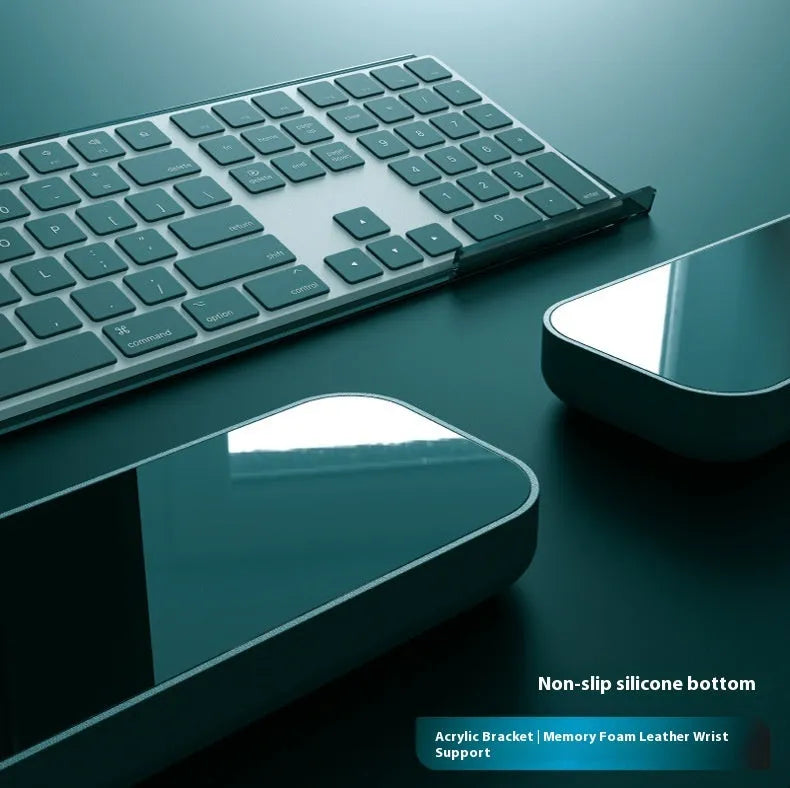 Double-sided black resin keyboard and mouse desk pad with integrated memory foam wrist rest.