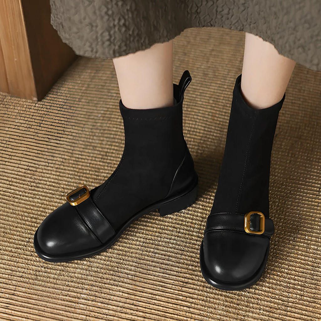 A pair of black women's lace-up Martin boots with a round toe and low rubber sole on a white background.