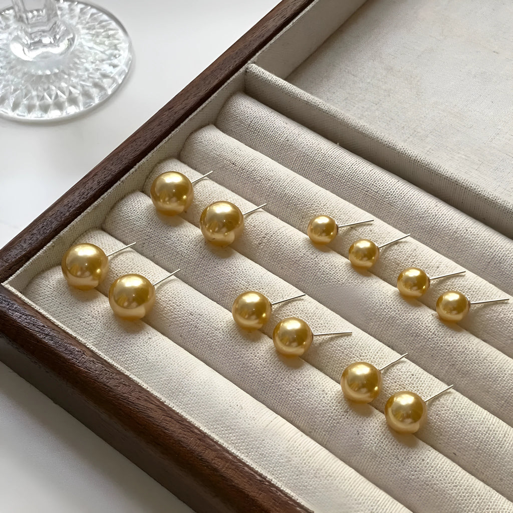 Close-up of retro-style geometric pearl stud earrings in silver, showing eight-awl star detail.