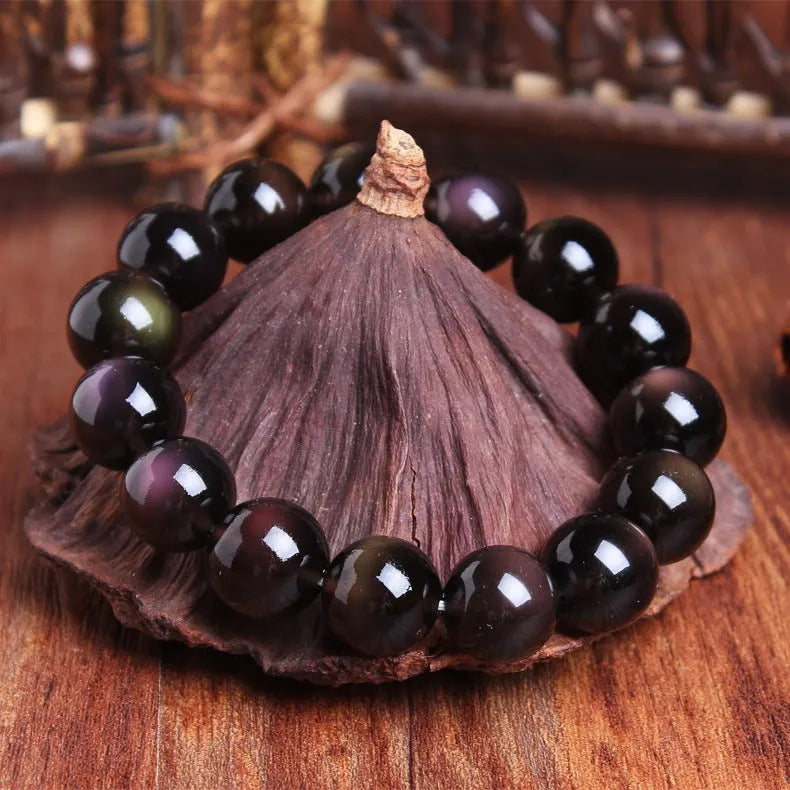 Polished crystal Pi Xiu bracelet with icy obsidian stone on wrist, showing geometric ethnic style.
