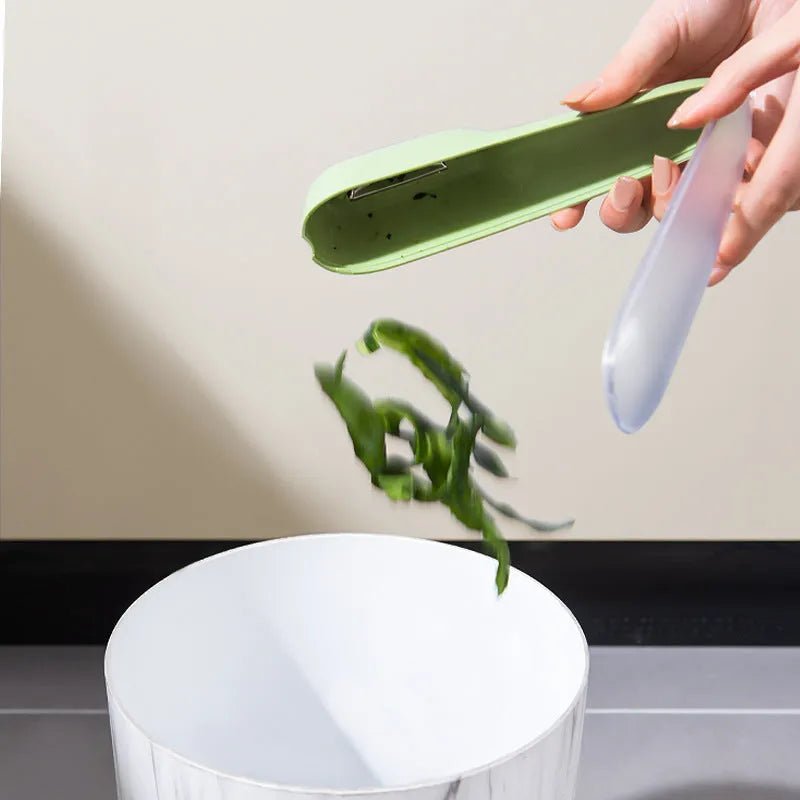 Dark green kitchen peeler with a storage tube and stainless steel blade, shown next to a potato.