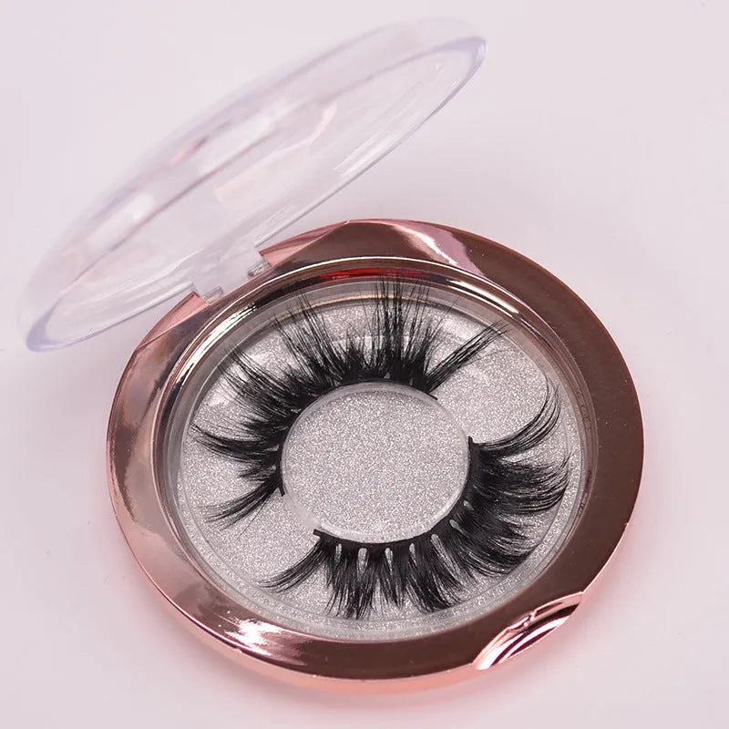 A pair of 5D mink false eyelashes with a hair cap and double-headed brush on a white background.