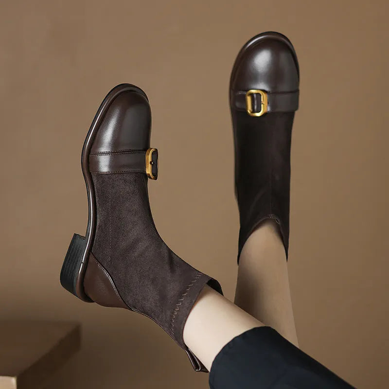 A pair of black women's lace-up Martin boots with a round toe and low rubber sole on a white background.