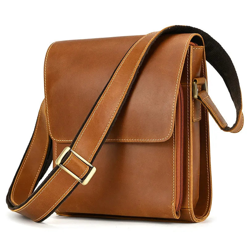 Dark brown cowhide leather crossbody shoulder bag for men on a table.