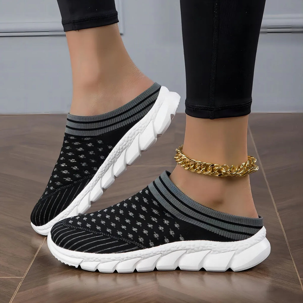 Women's black Flyknit slipper sock with striped pattern and hollowed-out design on a solid background.
