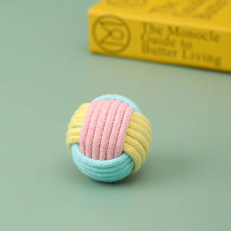 Four small handmade cotton plush balls for cats in assorted two-tone colours, shown next to a ruler for scale.