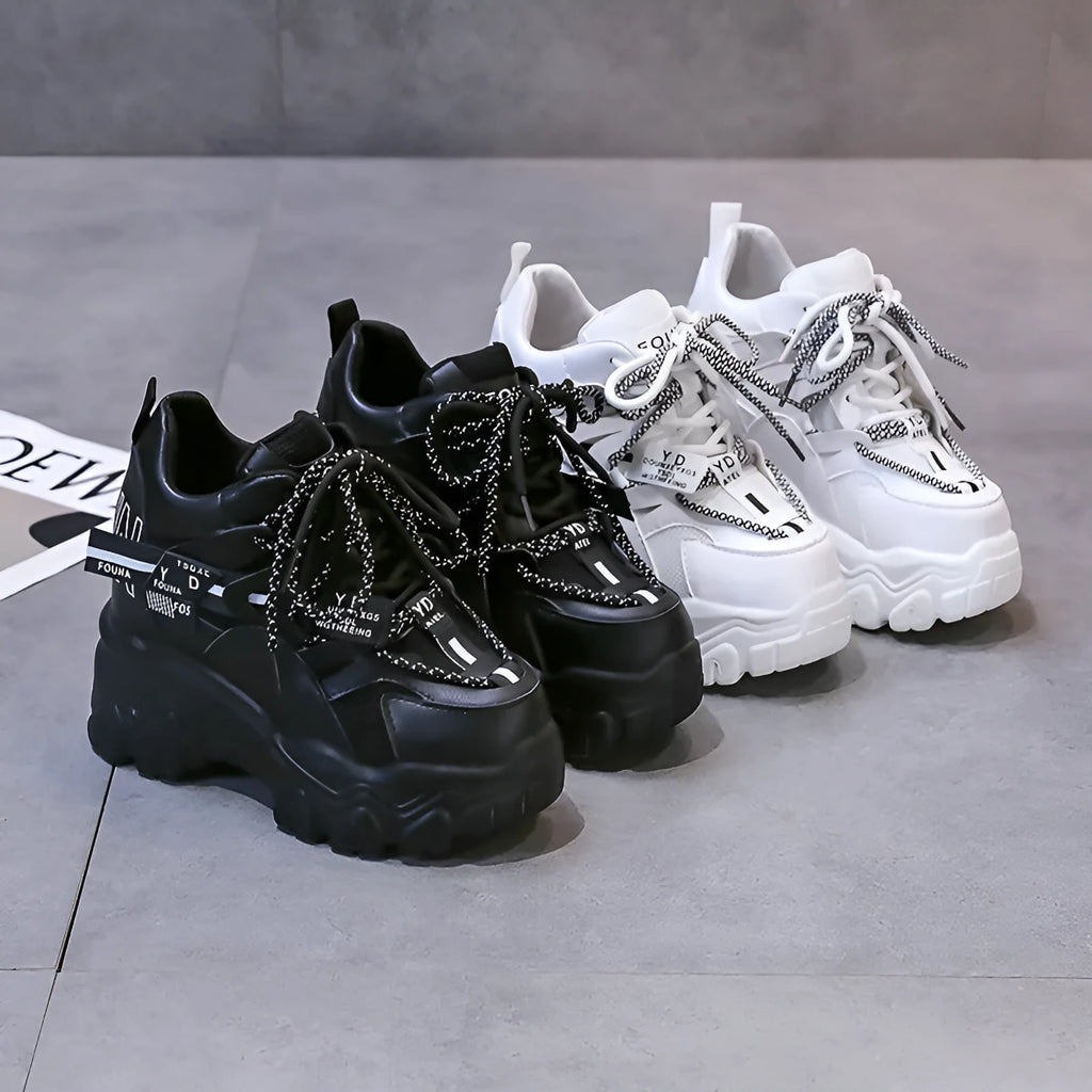 White women's low-top mesh sneakers with a black cross strap and a thick rubber platform sole.