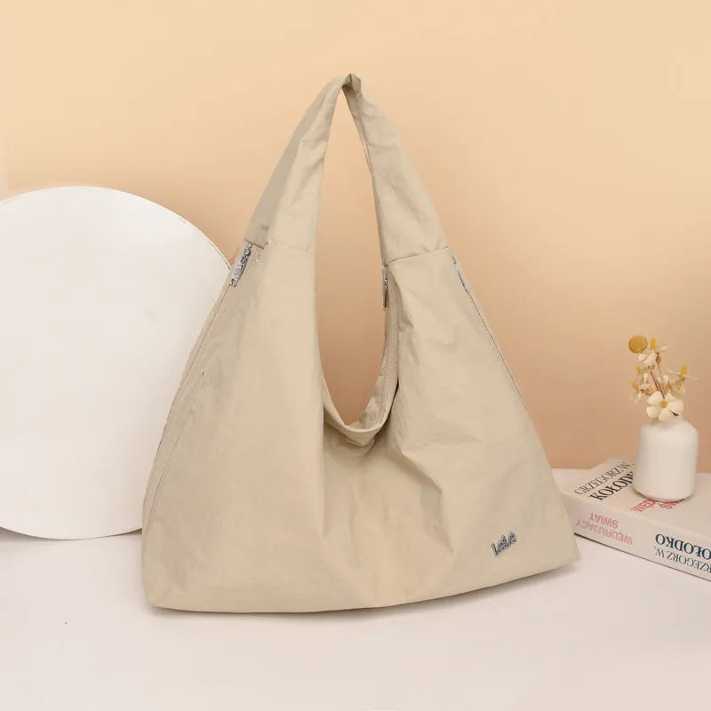 Soft nylon women's underarm bag in a heart shape, shown in black, blue, khaki, and yellow colours.