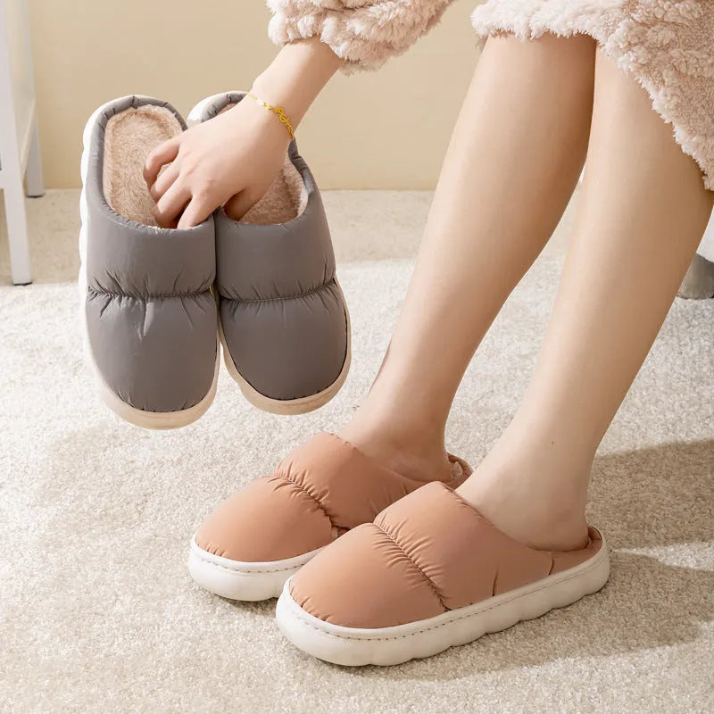 A pair of down cotton slippers with a thick rubber sole and artificial leather upper in a selected colour.