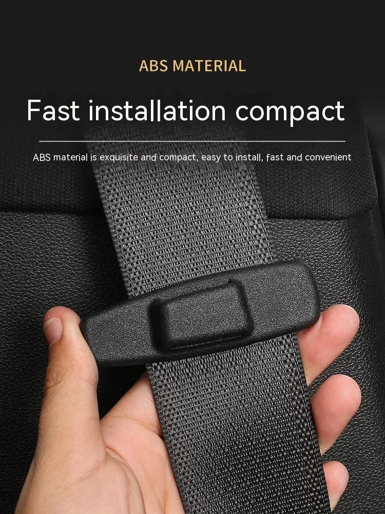 Two black ABS plastic universal car seat belt stopper clips on a grey background.