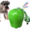 Green and red apple-shaped plastic dog toy with hollow treat-dispensing interior and squeaky sound mechanism