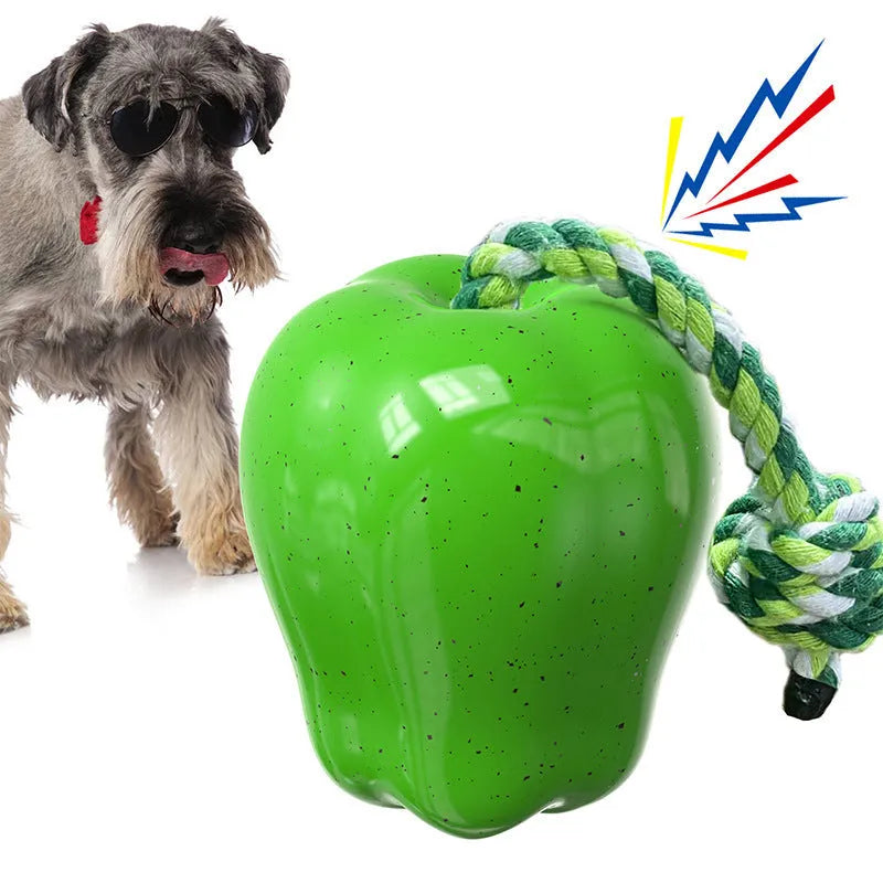 Green and red apple-shaped plastic dog toy with hollow treat-dispensing interior and squeaky sound mechanism