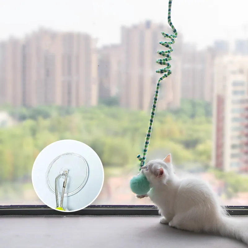 Hanging spring cat toy with bell and inflatable ball attached to window by suction cup