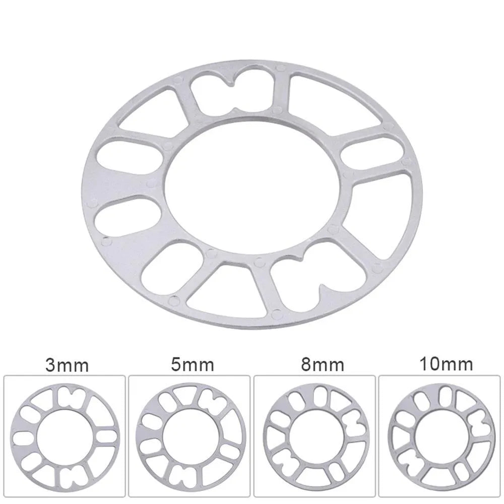 Hub centric wheel spacer kit for automotive modification in various thicknesses on a workshop bench.