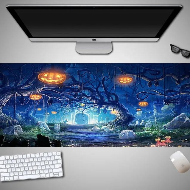 Oversized rectangular Halloween-themed mouse pad on a desk, showing one of 28 graphic designs.
