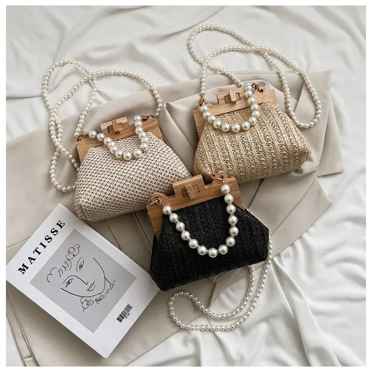 Women's woven straw shoulder bag with pearl chain detail in beige, showing horizontal square shape and single strap.