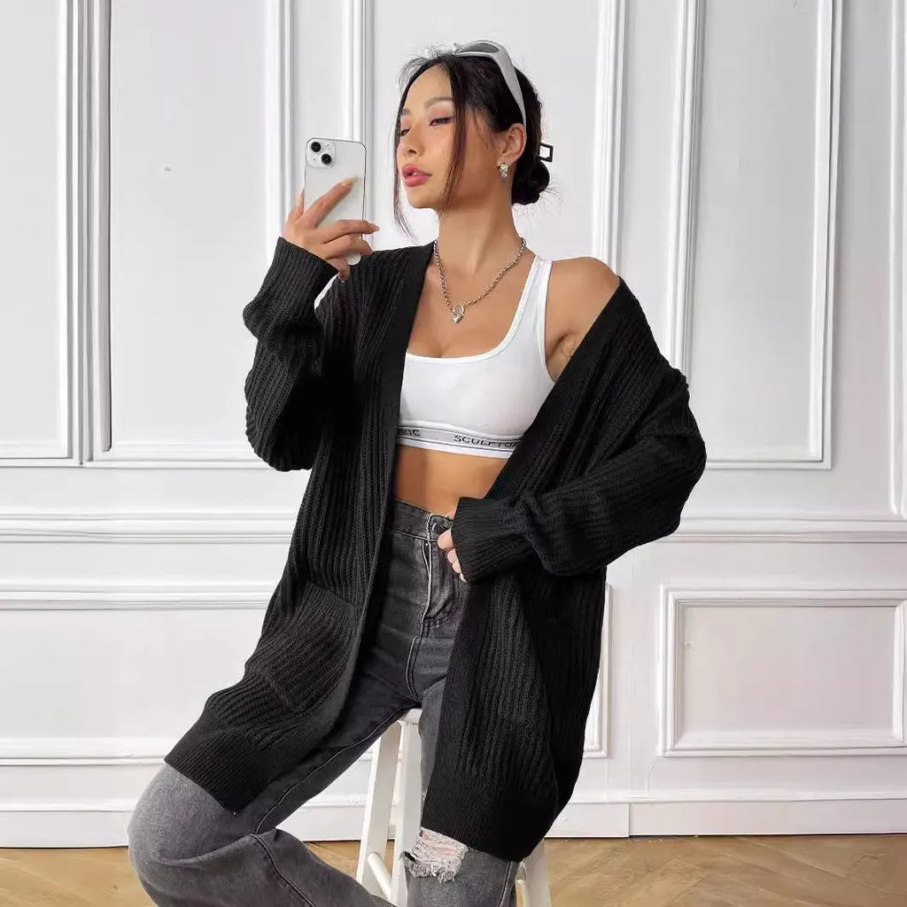 Women's dark green loose-fit mid-length acrylic cardigan sweater on a hanger.