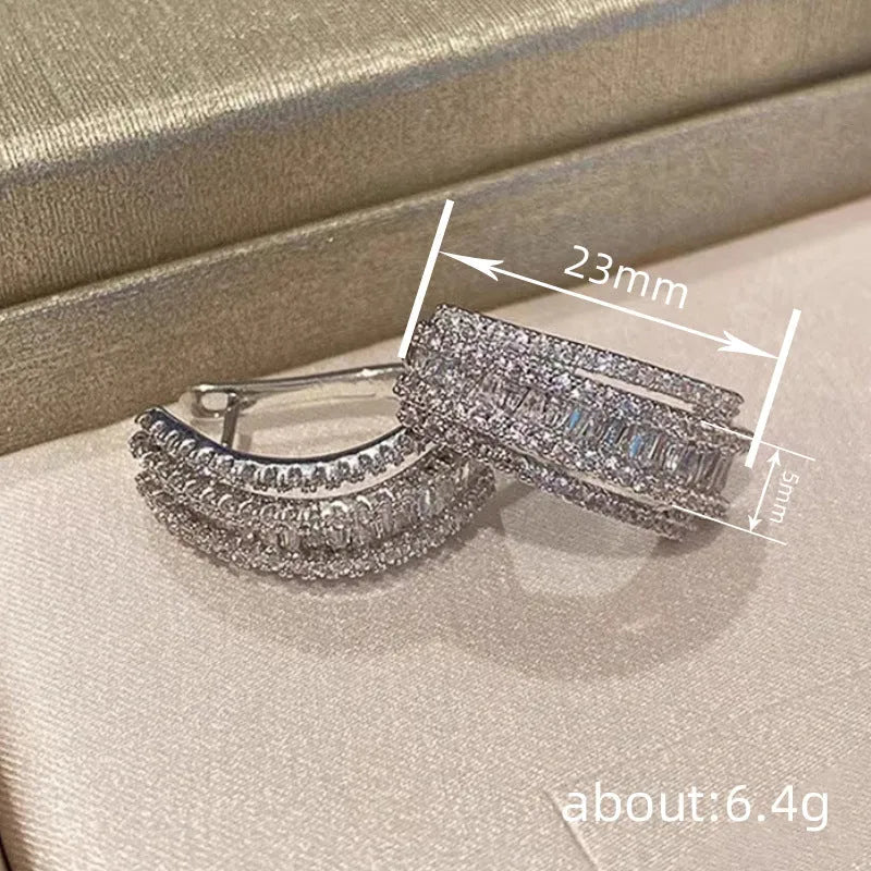 A pair of women's geometric stud earrings with inlaid zircon stones in a white gold colour finish.