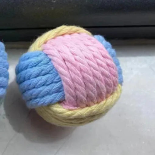 Four small handmade cotton plush balls for cats in assorted two-tone colours, shown next to a ruler for scale.