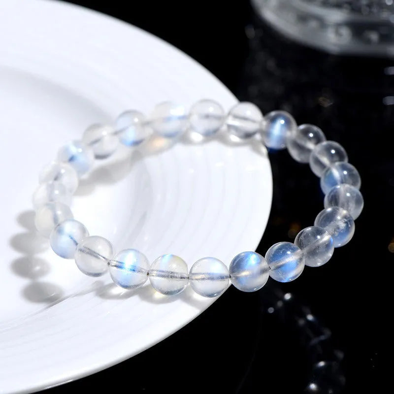 Natural blue moonlight crystal bracelet with smooth beads on a plain background.
