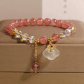 Women's crystal bracelet with strawberry quartz beads and white agate auspicious clouds design