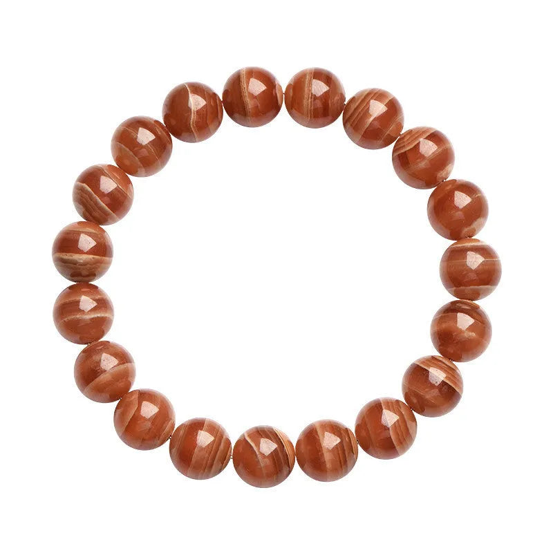 Natural old mine rhodochrosite round bead bracelet with ruyi design on a wrist.