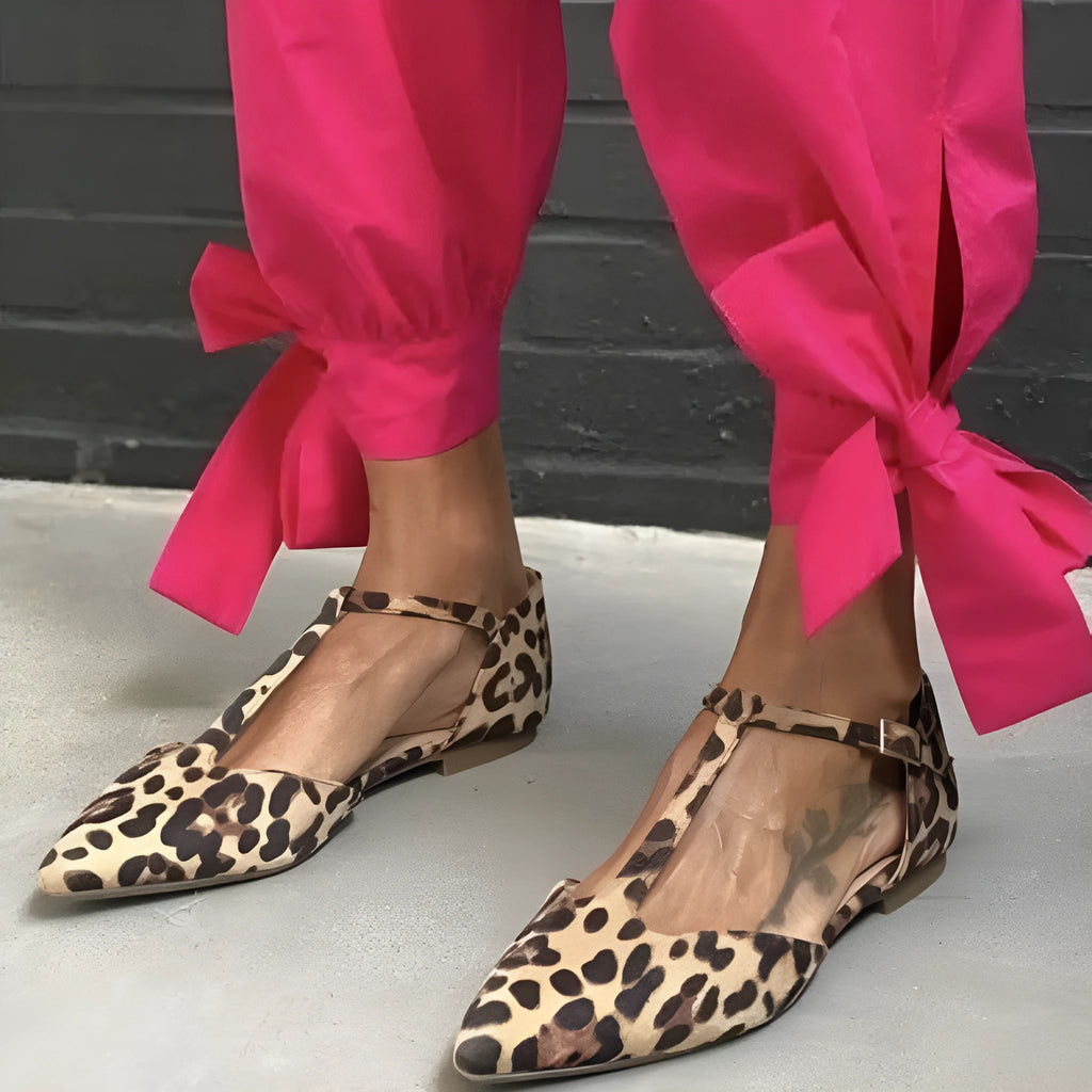 Leopard print women's pumps with pointed toe, cross strap, and a chunky low heel.