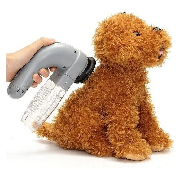 Grey handheld electric pet hair remover and massaging brush with soft rubber head.