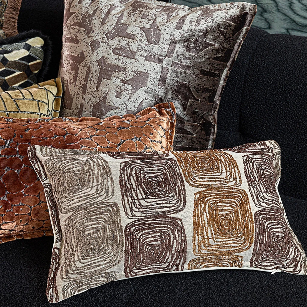 Cream and coffee-coloured abstract geometric coil pattern on a square pillow cover.