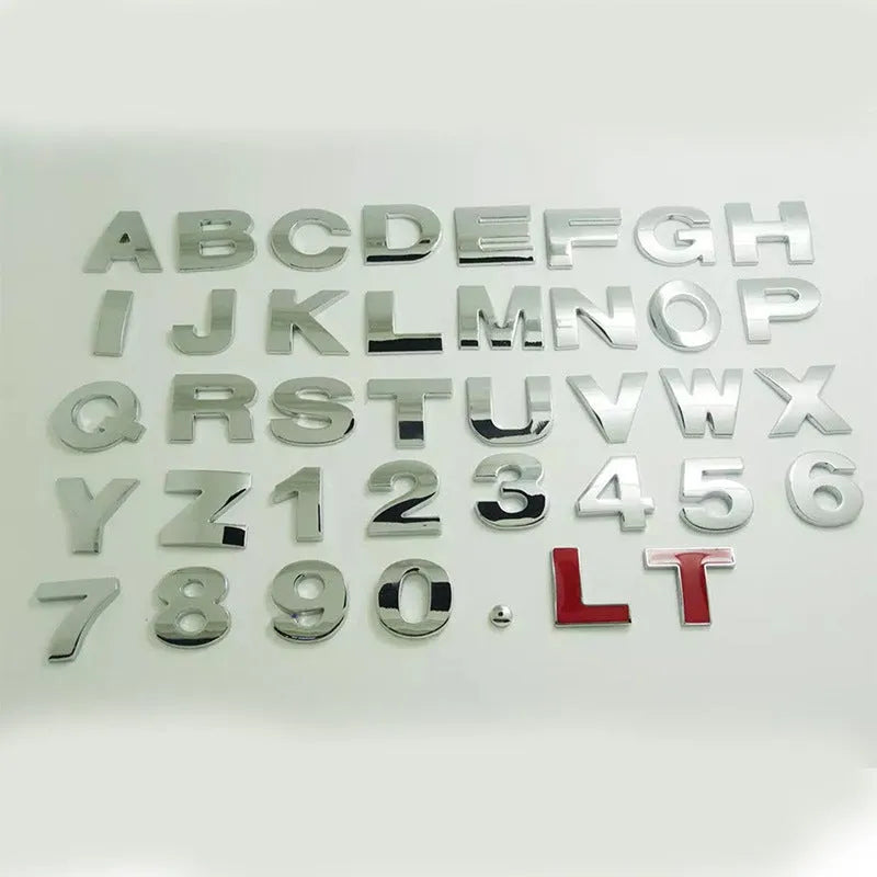 3D metal car letter sticker in zinc alloy, shown in black and silver finishes, approx. 2.5 cm in size.