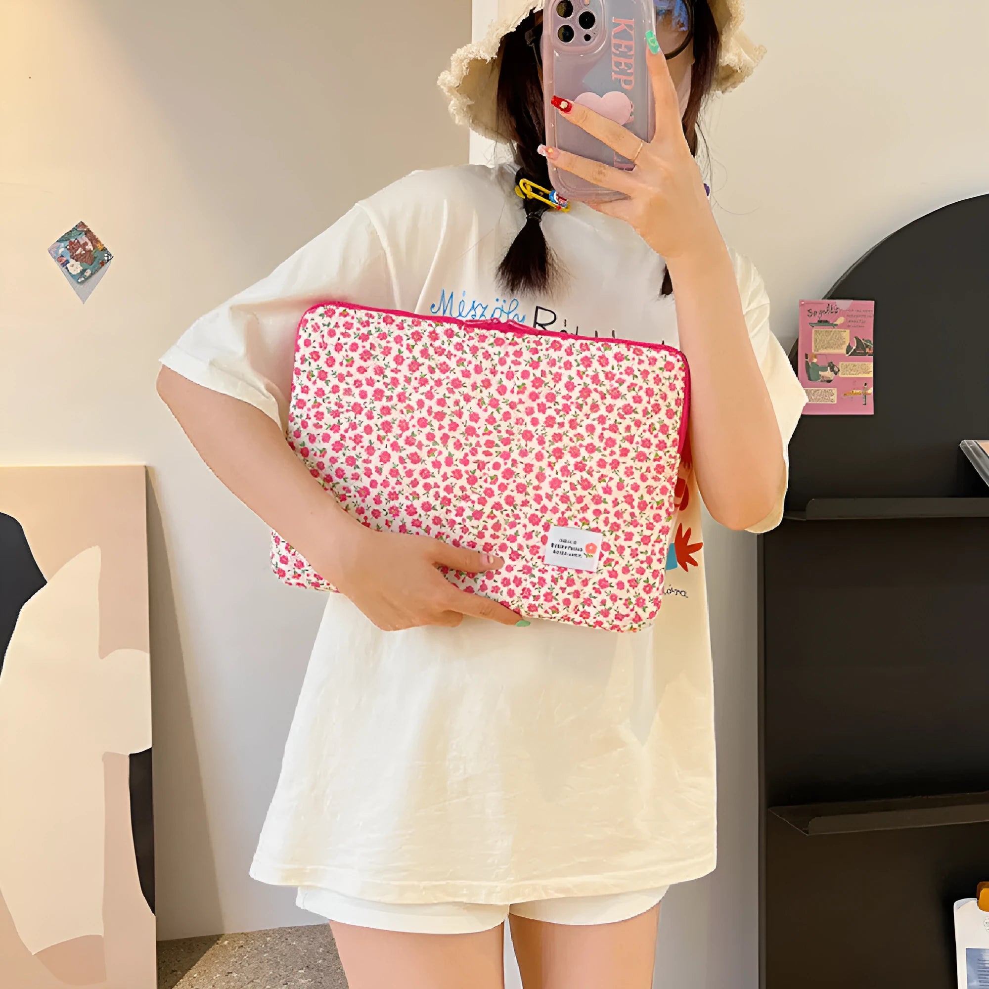 Printed cloth laptop bag showing floral and heart patterns in green, pink, and red colourways