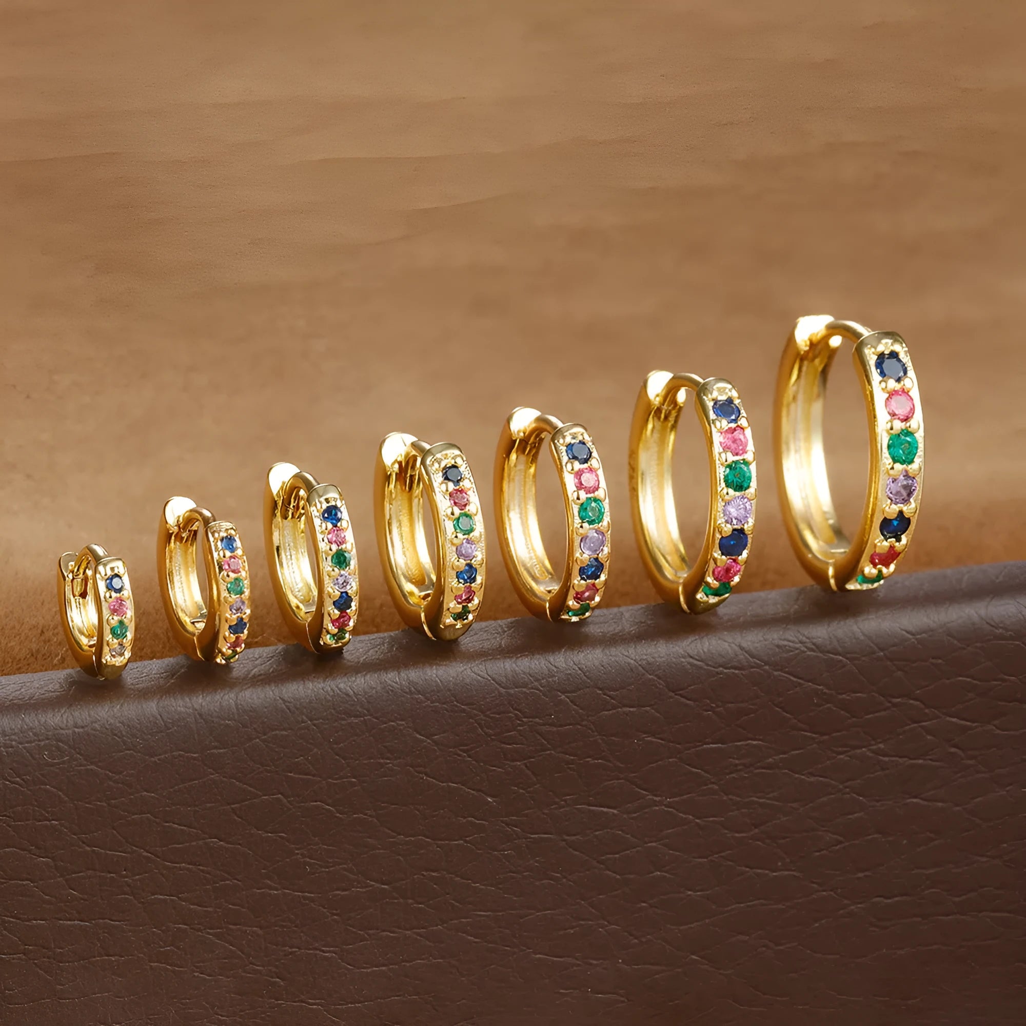 A pair of perforated geometric circle stud earrings with zircon details, shown in gold, rose gold, and silver colour options.