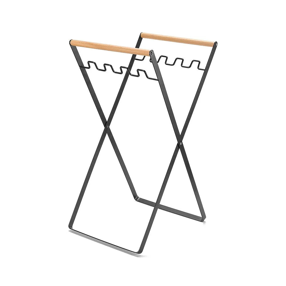 Black iron garbage storage hanger with wooden handle mounted on wall holding bin