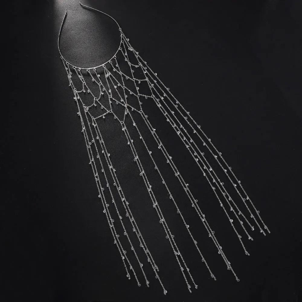 Gold coloured mesh headband decorated with rhinestones and a hanging tassel.
