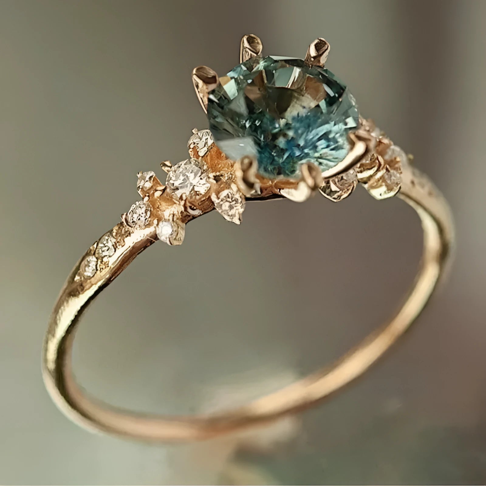 Gold plated alloy ring with geometric claw setting holding zircon stones in chamfered square pattern