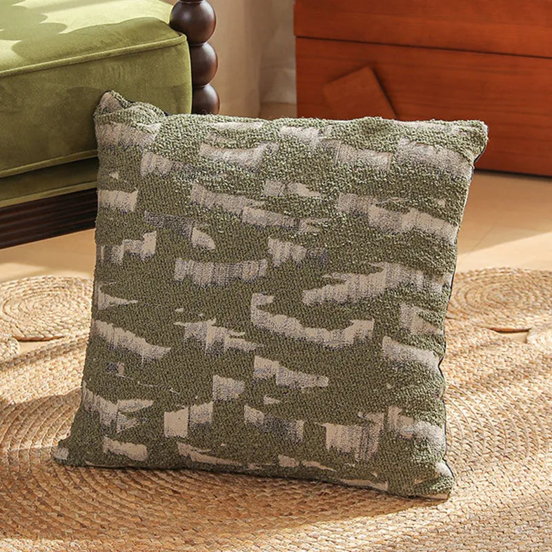 Square jacquard pillow cover with botanical pattern on a sofa, showing one of eight available colour options.