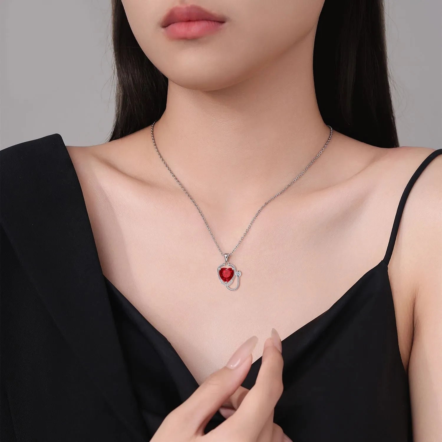 Women's fashion necklace with a copper wings cross stethoscope pendant featuring red diamond detail.
