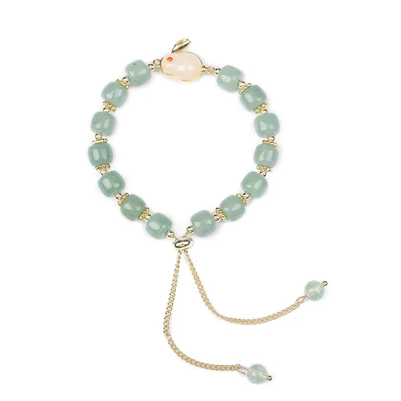 Women's rabbit charm bracelet with green aventurine or strawberry quartz beads, copper and gold accents.