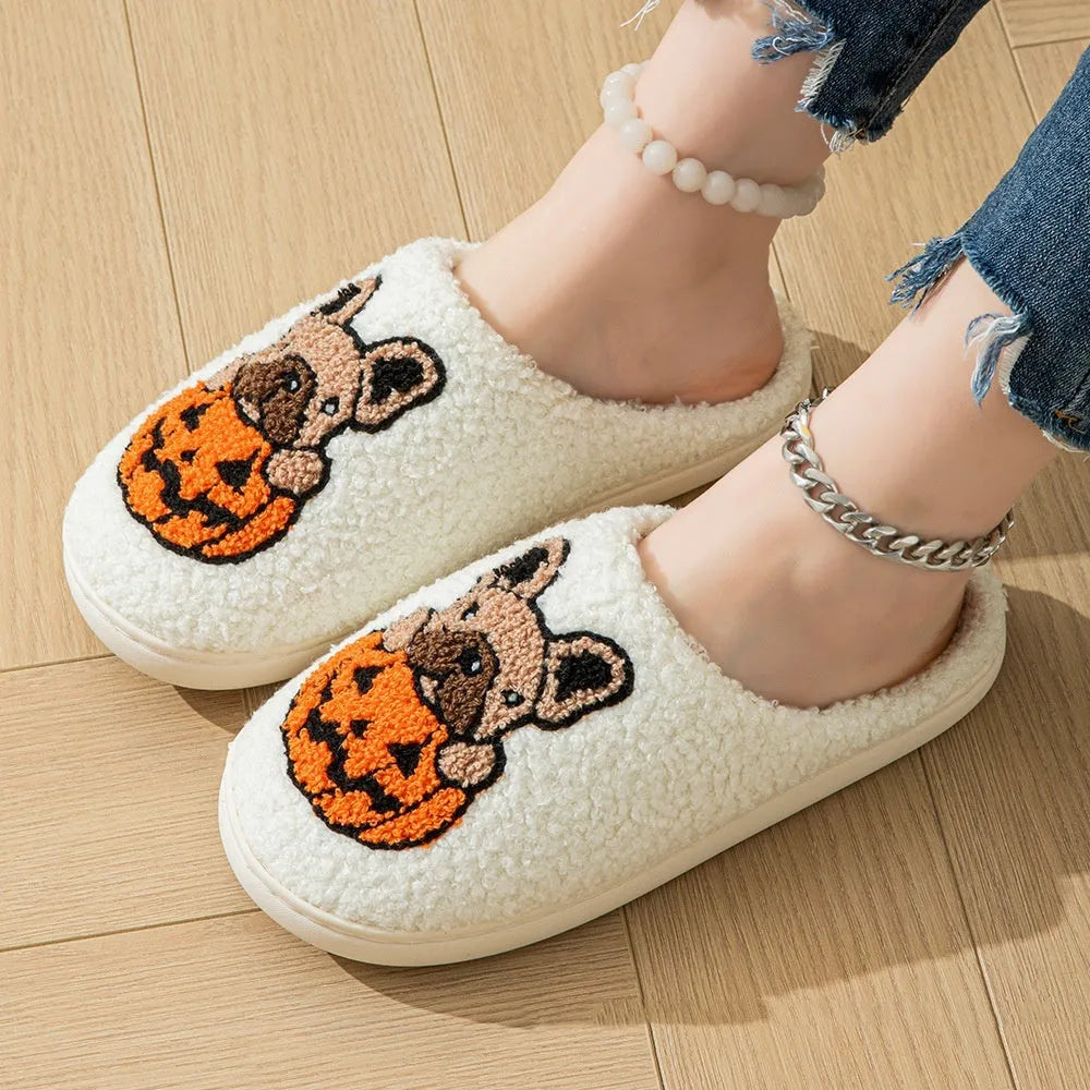 A pair of black and white Halloween-themed plush house slippers with rubber soles.